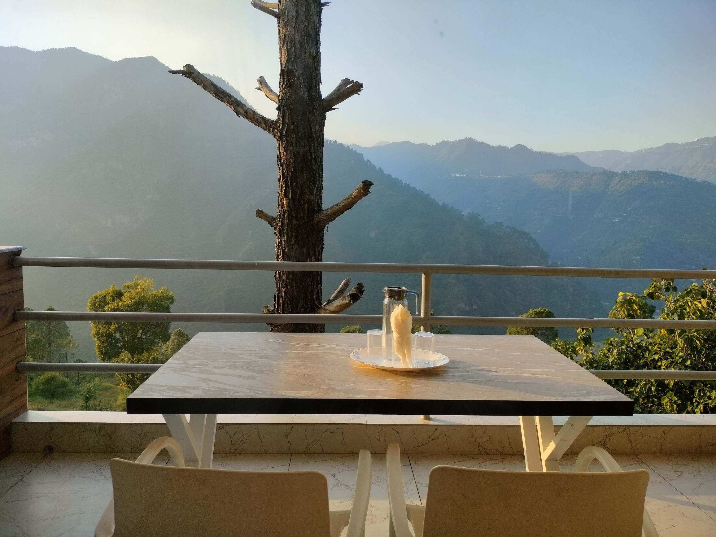 Balcony dining table set for two with mountain backdrop