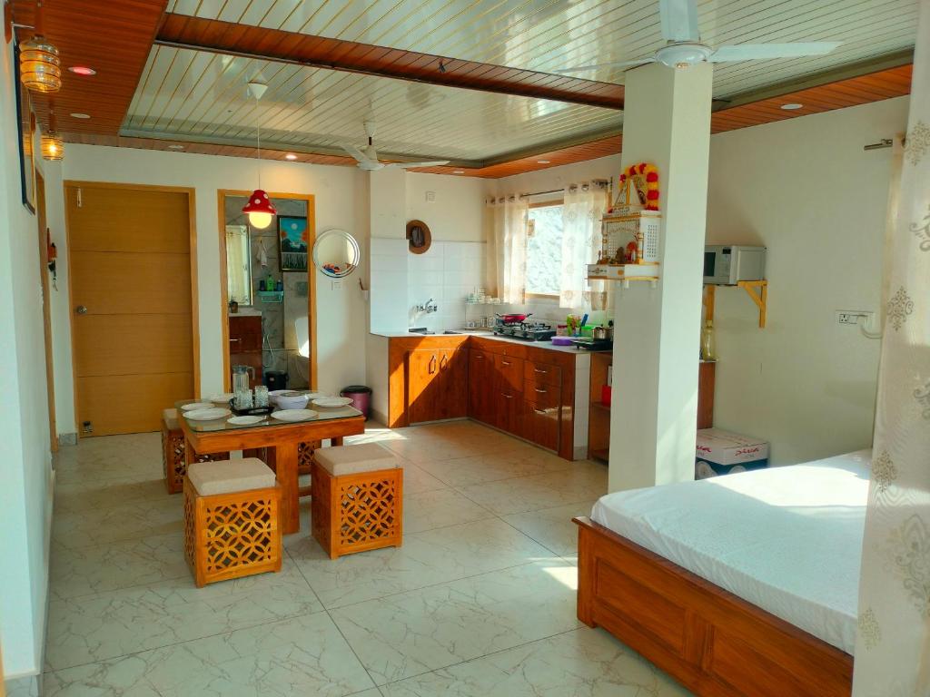 Apartment room with kitchenette, dining table, and bed